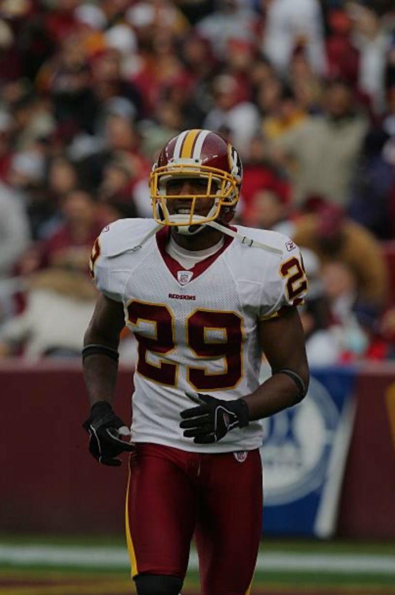 Mike Rumph in a Washington Redskins uniform, number 29, on the field in front of the stands